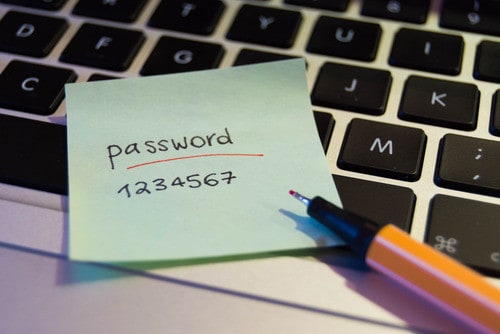 Close-up of a keyboard with notes: "password," "1234567," and "buy BTC" for buying crypto on Coinmama.